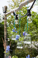 Creative garden lighting with hanging flower vases and fairy lights