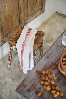 Towel lying over old stool with battered paint