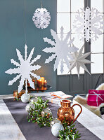 Paper snowflakes and stars hanging above a table