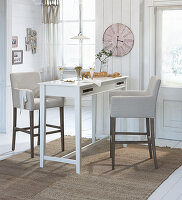 Upholstered bar stools at high table in rustic apartment