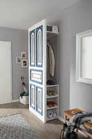 Entrance area with open wardrobe and blue and white cupboard element