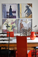 Holztisch mit Marmorplatte, schwarze und rote Stühle im Essbereich, Kunstwerke an der Wand