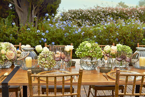 Table festively set with hydrangeas, roses and candle lanterns