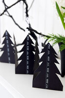 Fir trees made of black photo cardboard with Christmas greeting