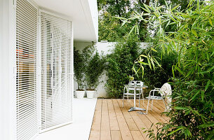 Sitzplatz auf der sichtgeschützten Terrasse am weißen Haus