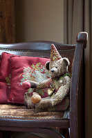 Scatter cushions and teddy bear on vintage leather couch