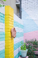 Brightly painted brick wall of urban courtyard garden