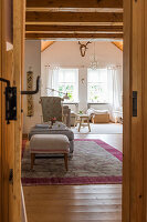 View through open wooden door into cosy, country-house-style living room