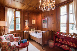 Old bed in classic wood-panelled child's bedroom