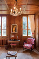 Pink-patterned armchair in traditional wood-panelled parlour