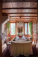 Festively set table in wood-panelled dining room
