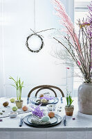 Easter table set with natural materials: eggs, grasses and twigs
