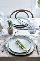 Tulips and willow catkins on plates on set table