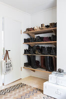 Shoes and boots on shoe rack fitted in niche