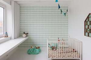 Children's room with diamond wallpaper, white crib and shelving unit