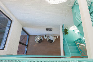 View of turquoise-colored staircase and seating from above