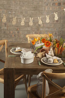 Garland of paper bunnies above rustically set Easter table