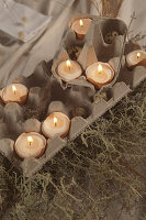 Arrangement of candles in egg shells in egg box