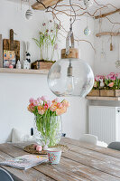 Vase of tulips on table in dining room with rustic spring decorations