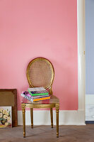 Medaillon-Stuhl mit Blattgold vor rosa Wand
