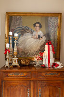 Christmas decorations and Baroque candlesticks in front of portrait of child