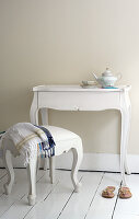 Baroque stool at console table against cream wall