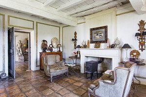 Cast iron stove and antique armchairs in interior room with tiled floor
