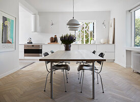 Dining table with classic chairs, white kitchen cabinets in the background