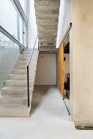 Concrete staircase next to glass wall