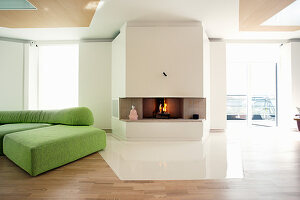 Fireplace and green modular sofa in living room