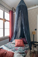 Bed with canopy in children's room with a high ceiling