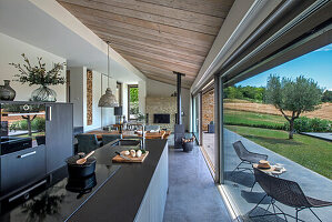 Elegante Küchenzeile in offenem Wohnraum vor Glasschiebetür und Terrasse