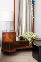 Antique bedside table with lamp and mirror in the bedroom