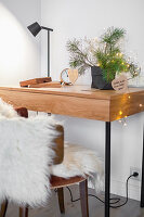 Small desk with Christmas decorations and chair with fur blanket