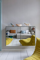 Hängeschrank mit Spiegeltüren, Spiegelbild von Sofa und Designersessel