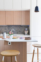 Helle Küche mit Kücheninsel und verlängerter Frühstückstheke in renovierter Altbauwohnung