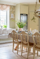 Festively set dining table with refrigerator and window seat in background