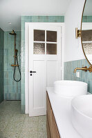 Open panelled door in classic bathroom with terrazzo floor and mint green walls