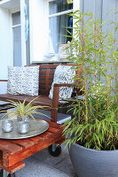Terrasse mit Bambus im Kübel, Bank und selbstgebautem Tisch aus Palette