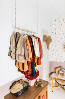 Kleiderstange mit Kleidungsstücken im Kinderzimmer