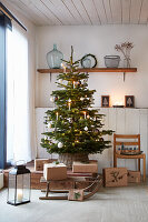 Geschmückter Weihnachtsbaum mit Geschenken und Holzschlitten