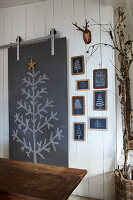 Tafel mit Kreidezeichnung eines Tannenbaums und weihnachtlicher Dekoration