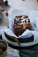 Homemade chocolate cake with nuts and sprinkles on a plate