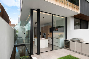 Terrace with refrigerator and pond and view through glass walls into kitchen