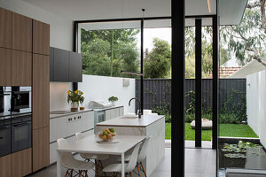 View from interior across dining and kitchen through glazing to rear courtyard garden