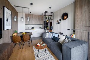 Open-plan interior with upholstered sofa, dining area and fitted kitchen