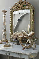 Antique gilt-framed mirror and vintage-style decorations on console table