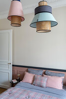 Pendant lights above bed with bed linen in pink and blue