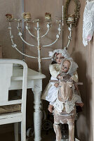 Antique dolls on rocking horse next to a candelabra