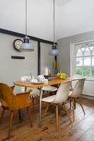 Dining area with wooden table, designer chairs and pendant lights